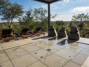 a group of chairs sitting on a patio at Kruger Lodge Mjejane in Hectorspruit