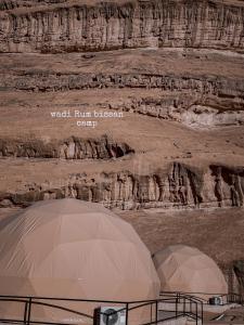 Disah的住宿－wadi Rum bissan camp，岩石悬崖前的2个帐篷