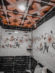 een badkamer met een toilet en bloemen op het plafond bij wadi Rum bissan camp in Disah