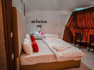 wadi Rum bissan camp في Disah: سريرين مع وسائد حمراء عليهم في غرفة