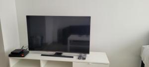 una TV a schermo piatto seduta su un supporto bianco di Studio fonctionnel proche RER B a Palaiseau