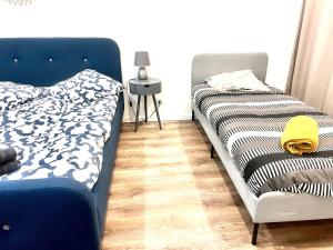 una camera con due letti e un divano blu di STNAHOME 60110 Perle d'Amblainville a Amblainville