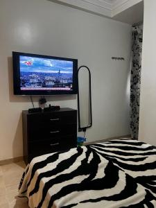 een slaapkamer met een flatscreen-tv en een bed bij studio meublé in Casablanca