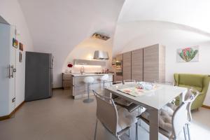 kuchnia ze stołem, krzesłami i lodówką w obiekcie La Corte dei Nespoli w mieście Acireale