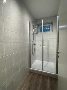 a shower with a glass door in a bathroom at Perfekt für 6! Küche Netflix BBQ Parkplätze in Haar