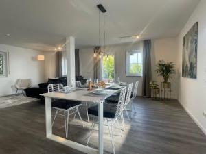 a dining room and living room with a table and chairs at Perfekt für 6! Küche Netflix BBQ Parkplätze in Haar