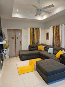 a living room with a couch and a ceiling fan at Summer Breeze Villa in Lucea