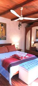 a bedroom with a large bed with a ceiling fan at Chalet Caserón de Tejas in Mar del Plata