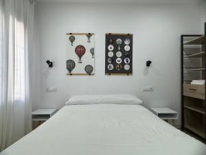 1 dormitorio con 1 cama y algunos artículos en la pared en Casa Luz, en Montoro