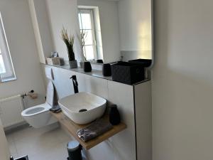 a bathroom with a white toilet and a sink at Whg 5 Traumhafte Ferienwohnung in Scharbeutz - für die ganze Familie! in Scharbeutz