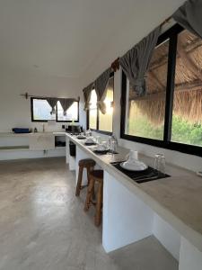 a bathroom with a long counter with sinks and windows at Kin studios holbox in Holbox Island