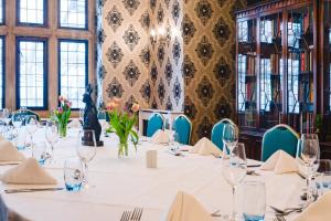 a dining room with tables and chairs and a waterfall at Cricklade House Hotel, Sure Hotel Collection by Best Western in Cricklade