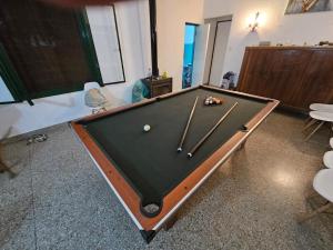 a pool table with cue sticks in a room at El Descanso in Villa Lía