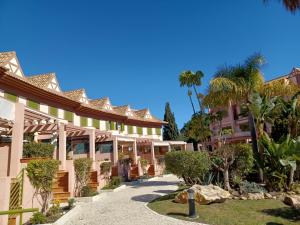 uitzicht op de binnenplaats van een resort met palmbomen bij Alojamiento dúplex en Islantilla in Islantilla