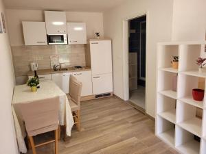 una cucina con tavolo e sedie in una stanza di Apartmani FILTEA a Vrsi (Verchè)