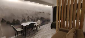 una sala de estar con una mesa y sillas en VistaRest Gudauri Ski Resort - by VistaRest Escapes & Stays, en Gudauri 29 fotos más