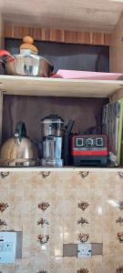 a kitchen shelf with various kitchen items on it at Umuahia, Abia Atate in Umuahia