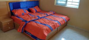 a bedroom with a bed with an orange and blue comforter at Umuahia, Abia Atate in Umuahia