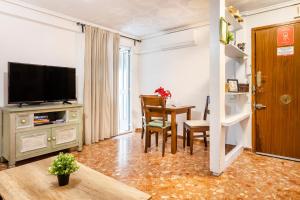 a living room with a table and a television at Big apartment at beach with terrace in Valencia