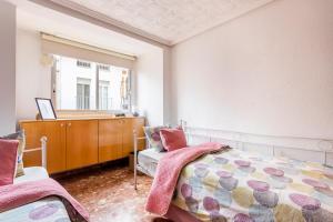 a bedroom with a bed and a dresser at Big apartment at beach with terrace in Valencia