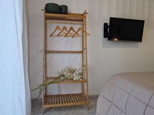 una mensola in legno con TV e fiori in camera di Elba2 a Bari