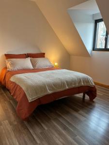 a bedroom with a large bed in a attic at Maison normande silex proche de la mer in Sotteville-sur-Mer