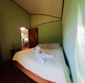 1 dormitorio con 1 cama con toallas en Granja los Campesinos, en Monteverde