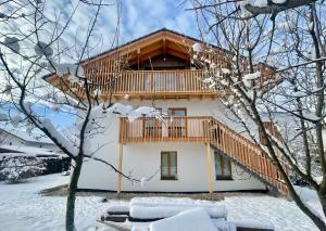 アシャウ・イム・キームガウにあるFerienwohnungen Bergluftの雪中の木製のデッキ付きの家