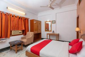 1 dormitorio con 1 cama y 1 silla en Collection O 5377 Hotel Raaj Bhaavan, en Chennai
