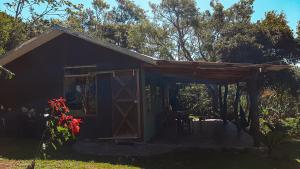 a small black shed with a open door at Granja los Campesinos in Monteverde Costa Rica +17 photos