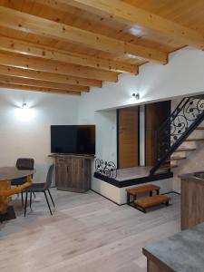 een woonkamer met een televisie en een trap bij Vikendica Striček in Kupres