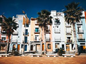 a building with palm trees in front of it at Big apartment at beach with terrace in Valencia