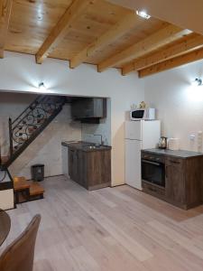 a large kitchen with wooden floors and a staircase at Vikendica Striček in Kupres