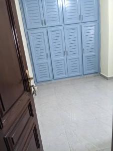 a room with blue doors and a white tile floor at Residence Mar-Pauli in Yaoundé