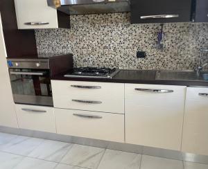 a kitchen with white cabinets and a stove at Casa Di Marzio in Pratola Peligna