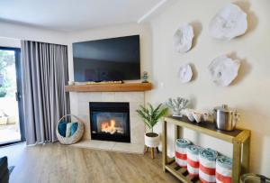 a living room with a fireplace and a flat screen tv at Luxury Villa - Flora View - Ground Level -Seascape in Aptos