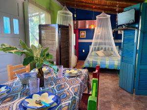 a dining room with a table and a bed at CABAÑA LA BOHEMIA in Colonia Hughes