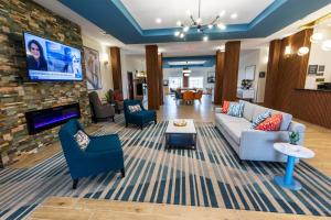 a living room with a couch and chairs and a tv at Comfort Inn & Suites New Iberia - Avery Island in New Iberia