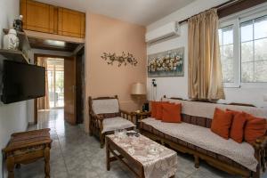 a living room with a couch and a tv at Dimitris studios & apartments in Faliraki