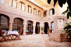 a large brick building with a table and chairs at casa rural Cieza de León in Llerena