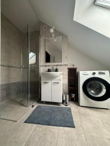 a bathroom with a washing machine and a sink at Apartament Oksford 3 in Okszów