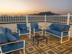 einen Balkon mit blauen Stühlen und einem Tisch in der Unterkunft ملك فيلا in Medina