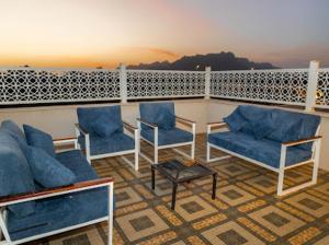 a balcony with blue chairs and a table at ملك فيلا in Al Madinah