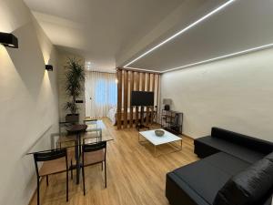 uma sala de estar com um sofá e uma mesa em SlabonHome Serrallo em Granada