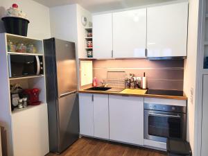 a kitchen with white cabinets and a stainless steel refrigerator at Candyland - Disneyland & Family in Meaux