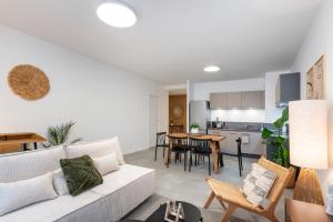 Il comprend un salon avec un canapé blanc et une cuisine. dans l'établissement Les Cocons Montchat, à Lyon