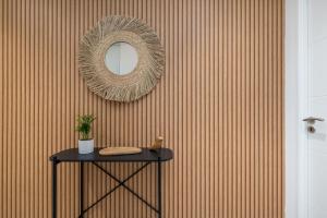 einen Spiegel an einer Wand mit einem Tisch in einem Zimmer in der Unterkunft Les Cocons Montchat in Lyon