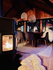 a room with a fireplace and a table with chairs at Chalet - Kleines Paradies - in Appenzell