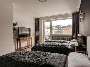 a hotel room with two beds and a window at Downtown Apartments Unterbilk in Düsseldorf