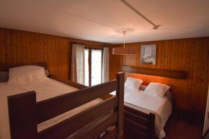 a bedroom with two bunk beds and a window at Hôtel Le Chinfrey in Les Gets